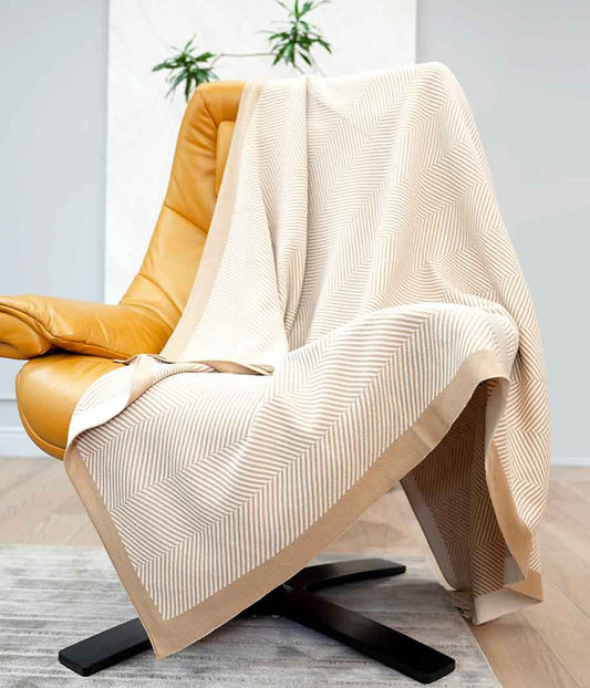 Throw blanket in brown beige with stripe patterns on a chair