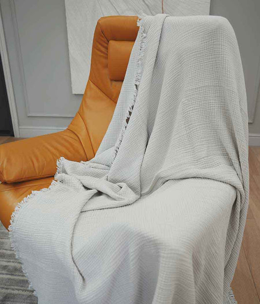 Cotton throw blanket in silver grey put on chair