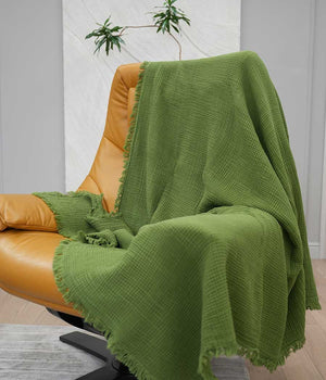 green cotton blanket on a chair