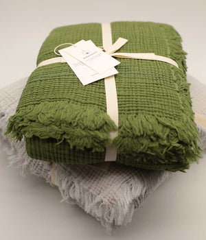 Cotton throw blanket in grass green folded