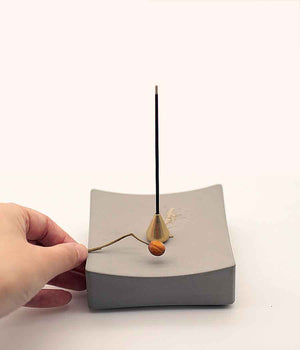 Concrete incense burner in white background with a hand 